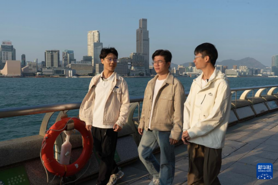 2月17日,在香港湾仔海滨长廊拍摄的何金淼(中)、温建彬(右)和王皓霖。新华社发(龙镜伊摄)